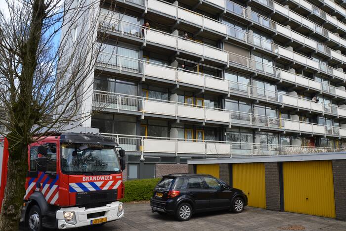 Brandweer blust brandende wasmand