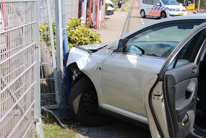 Auto knalt op hekwerk bedrijfspand