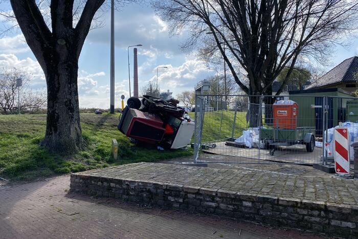 Grasmaaier valt van dijk af
