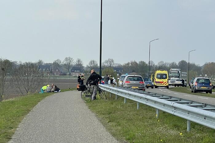 Auto glijdt van dijk af na botsing en vliegt in brand