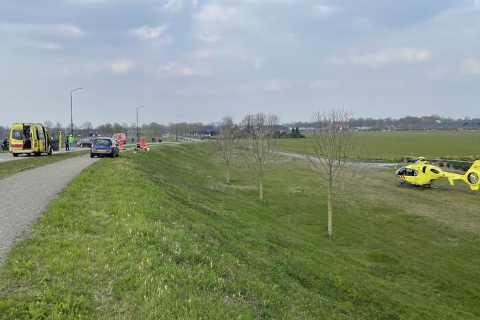 Auto glijdt van dijk af na botsing en vliegt in brand