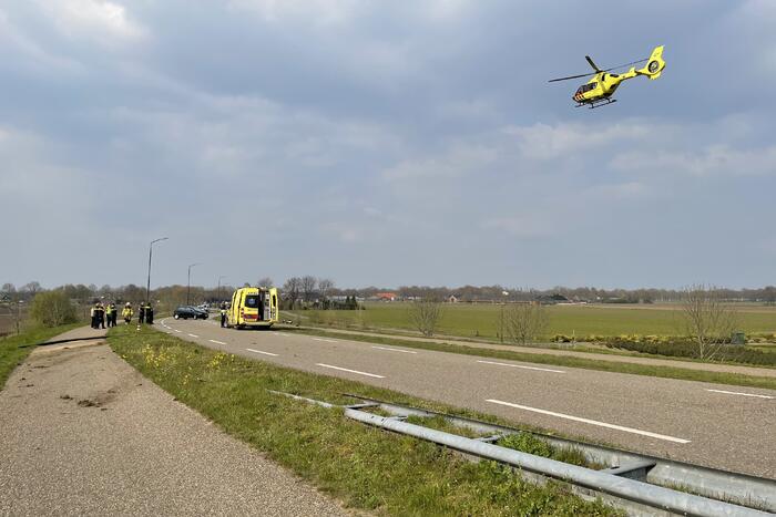 Auto glijdt van dijk af na botsing en vliegt in brand