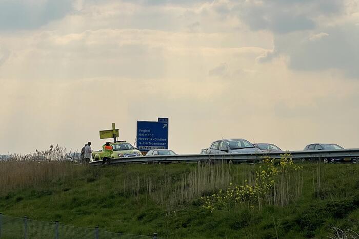 Auto glijdt van dijk af na botsing en vliegt in brand