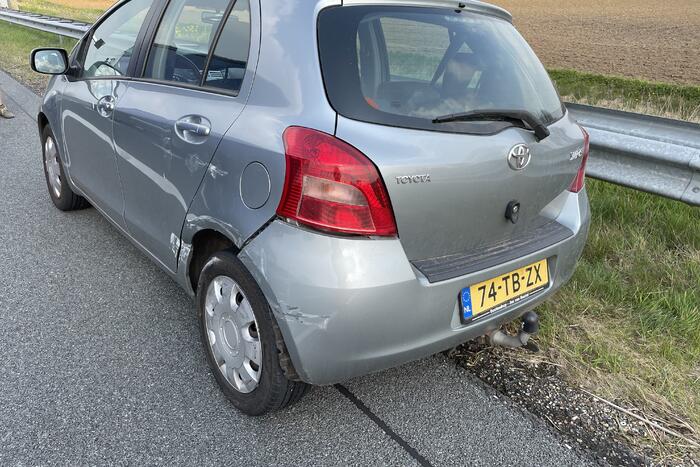 Auto glijdt van dijk af na botsing en vliegt in brand