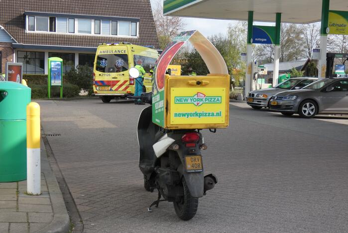 Maaltijdbezorger geholpen door ambulancepersoneel na val