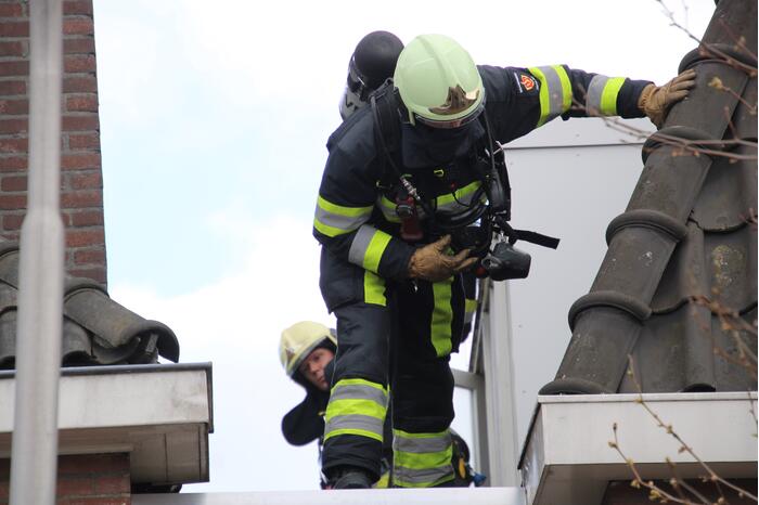 Brandweer blust brand op dak