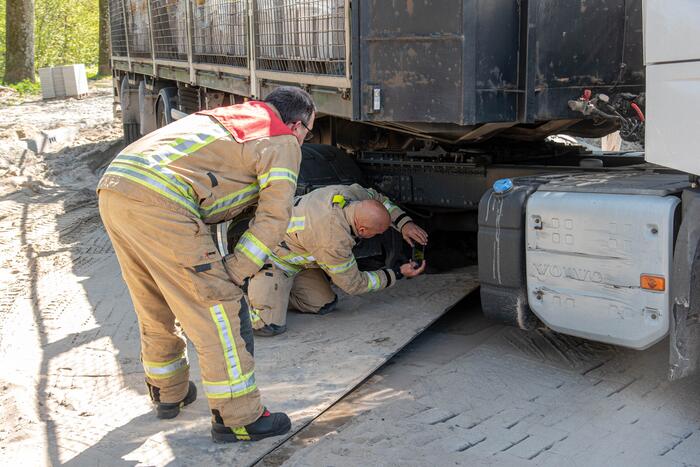 Vrachtwagen vast in het zand en verliest brandstof door lek
