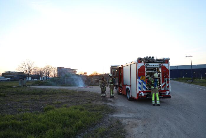 Brandweer blust brandende pallets
