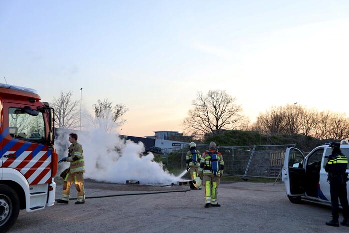 Brandweer blust brandende pallets