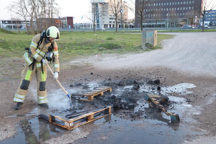 Brandweer blust brandende pallets
