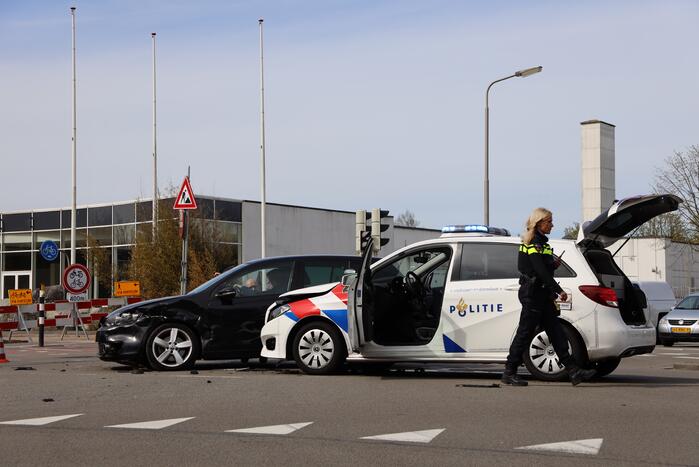 Politieauto met spoed ramt personenauto