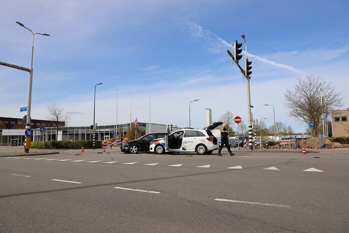 Politieauto met spoed ramt personenauto