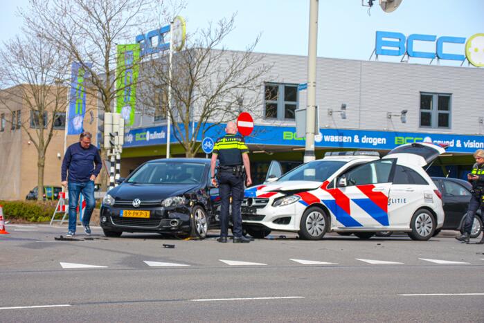 Politieauto met spoed ramt personenauto