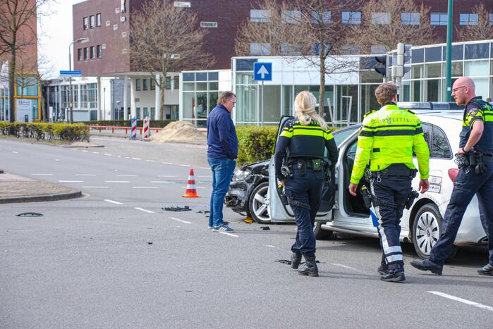 Politieauto met spoed ramt personenauto