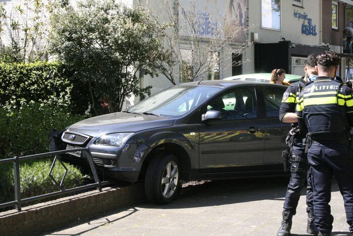 Bestuurder rijdt met auto op tuinhek