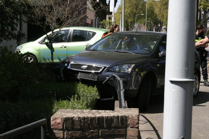 Bestuurder rijdt met auto op tuinhek