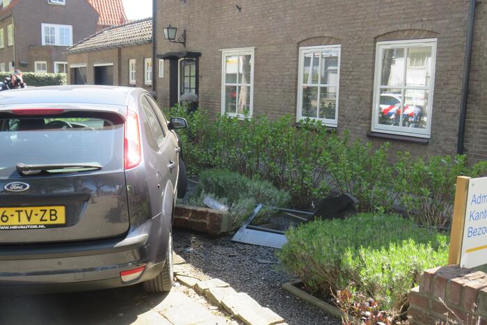 Bestuurder rijdt met auto op tuinhek