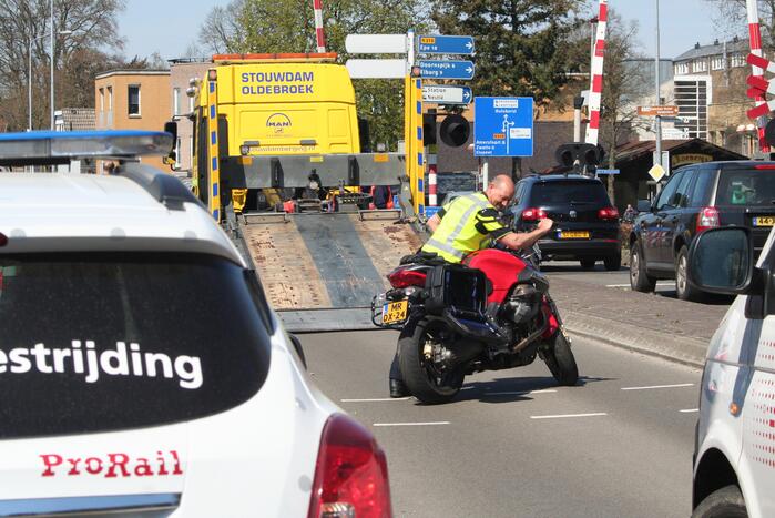 Motor heeft veel schade door botsing met personenauto en trein