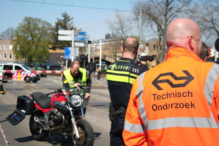 Motor heeft veel schade door botsing met personenauto en trein