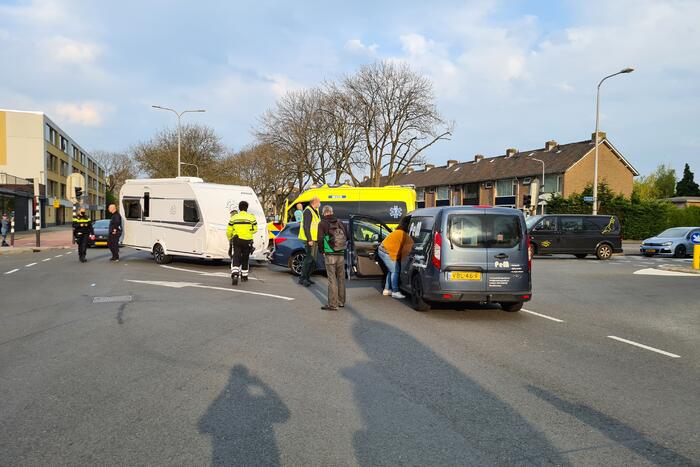 Personenauto met caravan in botsing met bestelbus