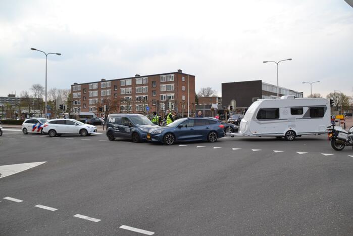 Personenauto met caravan in botsing met bestelbus