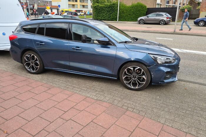 Personenauto met caravan in botsing met bestelbus
