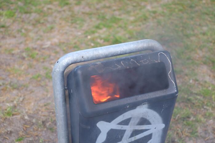 Brandweer blust brand in afvalcontainer