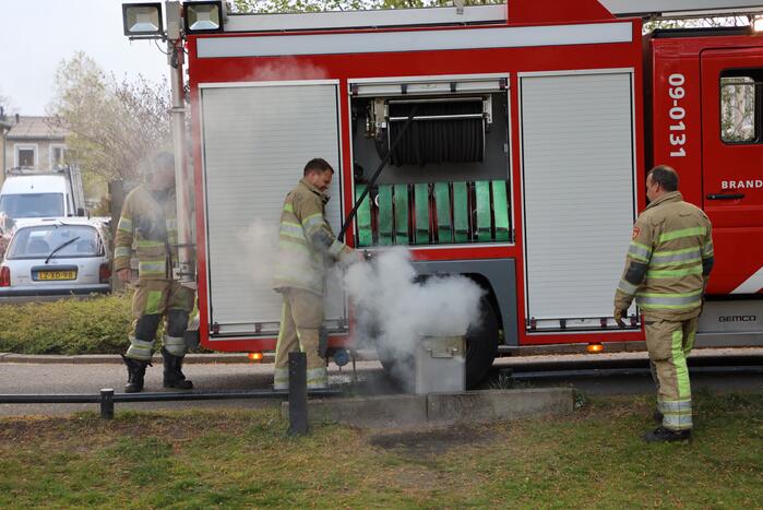 Brandweer blust brand in afvalcontainer