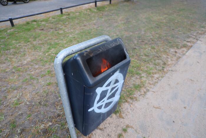 Brandweer blust brand in afvalcontainer