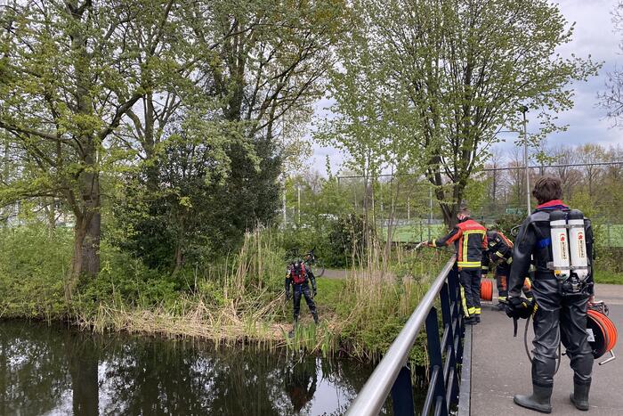 Brandweer duikt in het water gevallen telefoon op