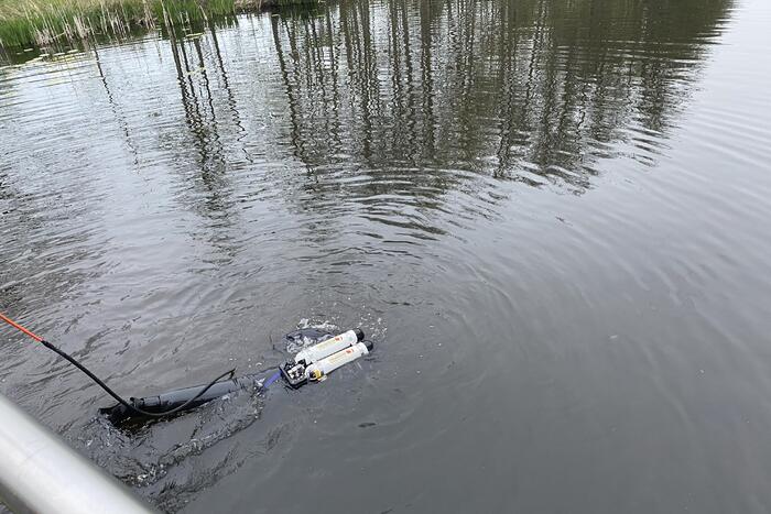 Brandweer duikt in het water gevallen telefoon op