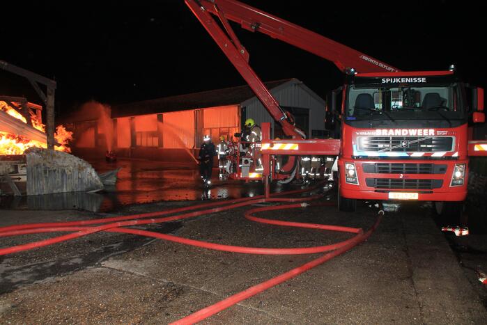 Brandweer bestrijdt grote uitslaande brand in twee loodsen