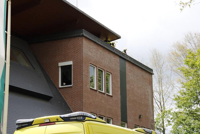 Persoon vast op dak van bedrijfspand