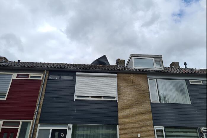 Dakbedekking waait van dakkapel van woning