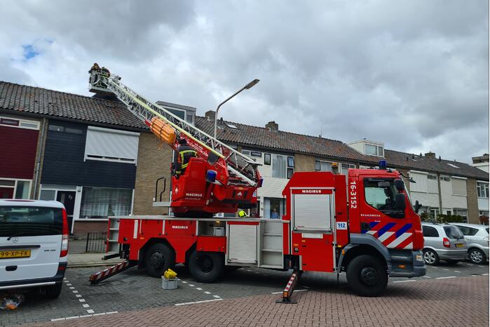 Dakbedekking waait van dakkapel van woning