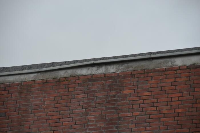 Brandweer boort schroeven in bijna loskomende dakrand