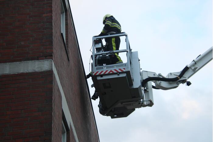 Brandweer boort schroeven in bijna loskomende dakrand
