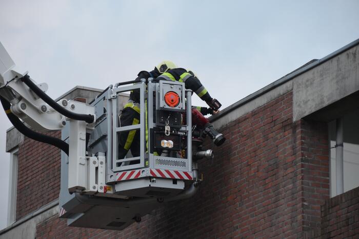Brandweer boort schroeven in bijna loskomende dakrand