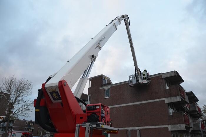 Brandweer boort schroeven in bijna loskomende dakrand