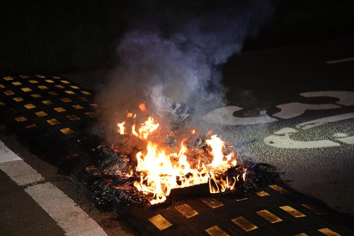 Brandweer blust brandende band op midden van weg