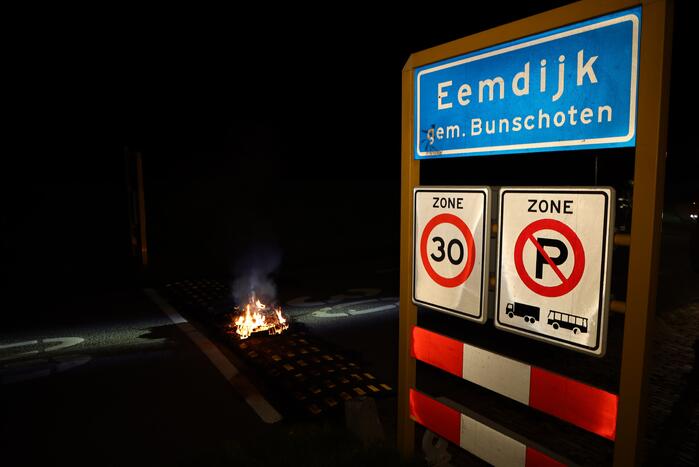 Brandweer blust brandende band op midden van weg