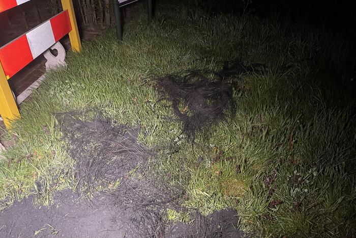 Brandweer blust brandende band op midden van weg