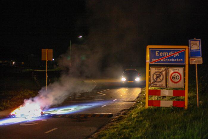 Brandweer blust brandende band op midden van weg