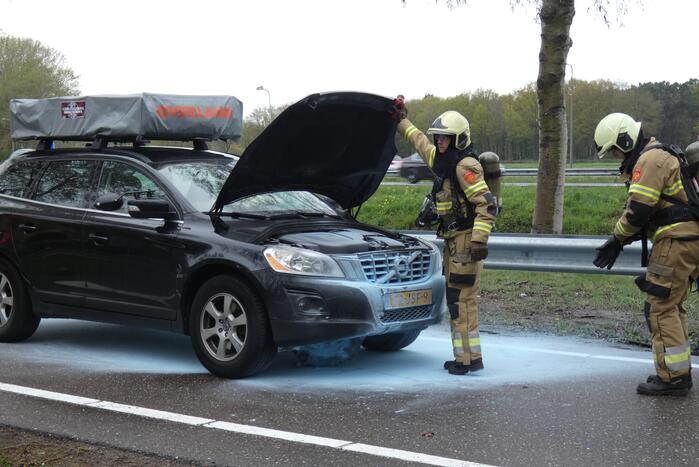Brandweer blust brand in motorcompartiment van personenauto