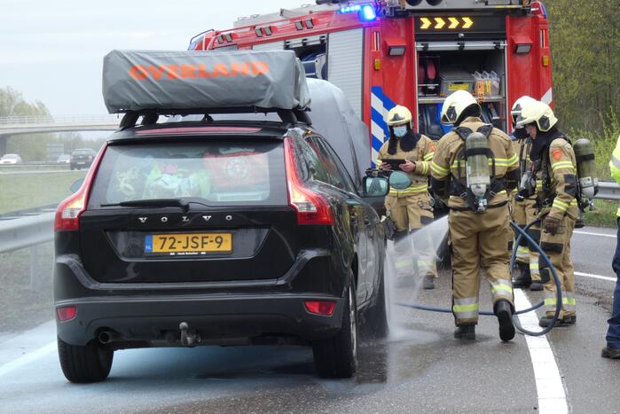 Brandweer blust brand in motorcompartiment van personenauto