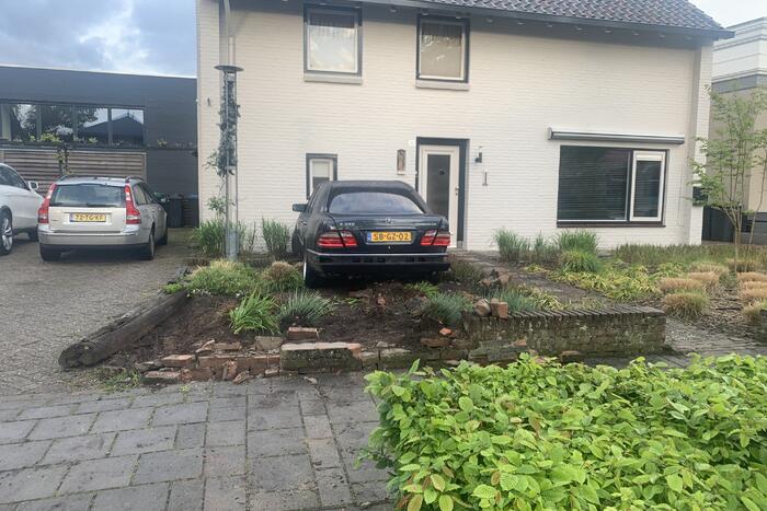 Auto rijdt door voortuin en tegen woning
