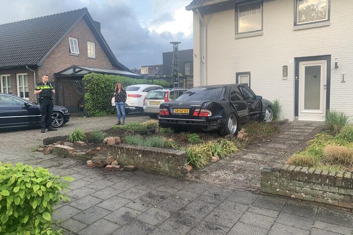 Auto rijdt door voortuin en tegen woning