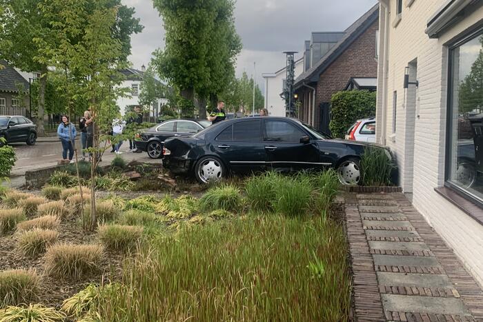 Auto rijdt door voortuin en tegen woning