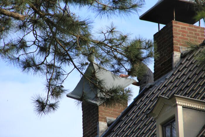 Brandweer zet schoorsteenkap terug
