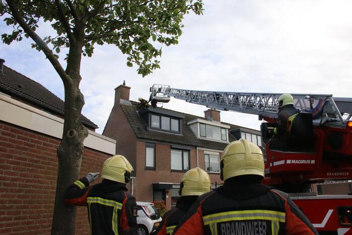 Brandweer legt weggewaaide dakpannen terug